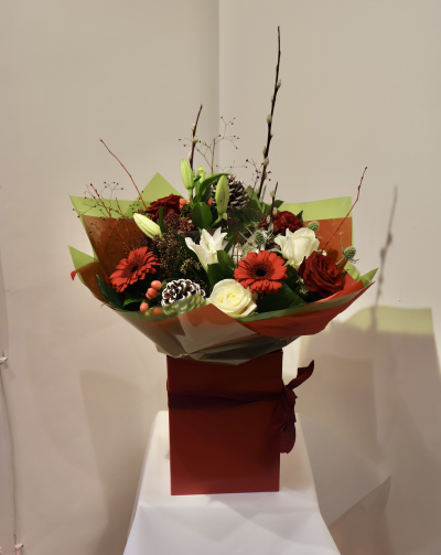 Christmas Morning by Octagon Flowers, Bolton - Festive Christmas gift box arrangement with red and white flowers, pinecones and winter greenery. Handcrafted by Octagon Flowers Bolton. Perfect for gifting.