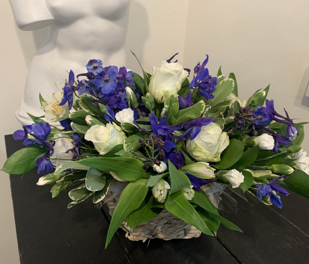 Blue Delphinium white roses and white carnations basket tribute